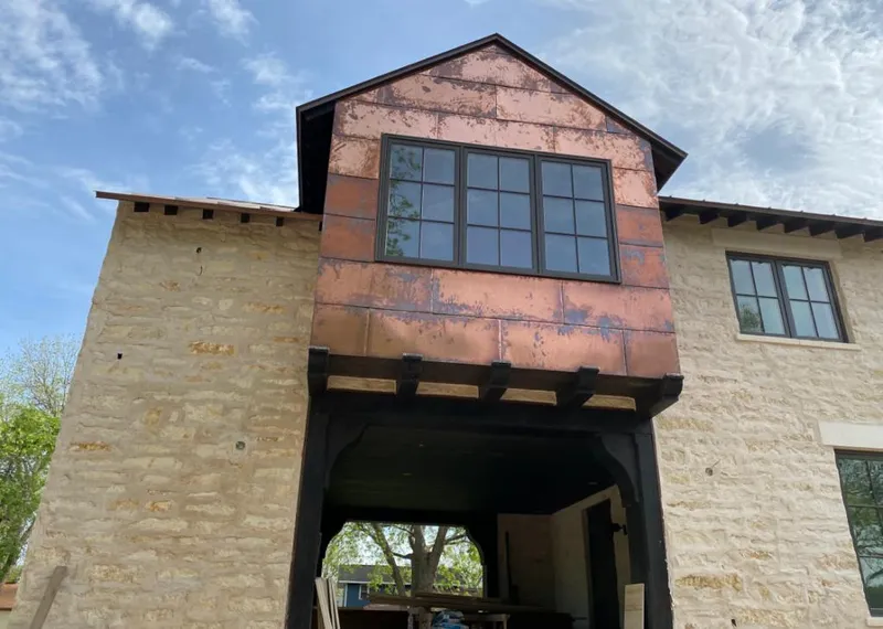 Copper metal panel facade on a stone building for Roof Repair in Long Grove